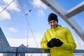 Portrait of young athlete man in windbreaker using smart-phone