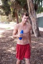 Portrait of a young athletic runner with water bot