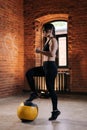 Portrait of young athletic woman with strong beautiful body in sportswear exercising with heavy medicine ball during Royalty Free Stock Photo