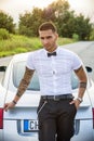 Handsome young man next to car in white shirt Royalty Free Stock Photo