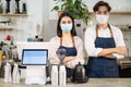 Portrait of young attractive Asian waiter and waitress wearing protective mask due to Covid-19 pandemic at cafe. Barista business Royalty Free Stock Photo