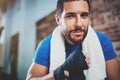 Portrait of Young attractive athlete tying black boxing bandages.Boxer man prepairing before kickboxing training Royalty Free Stock Photo