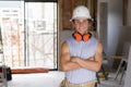 Portrait of young attractive builder man on his 20s posing happy confident and proud at construction site wearing protection helme Royalty Free Stock Photo