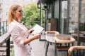 Portrait of young attractive businesswoman examining paperwork in bight light office interior sitting next to the window