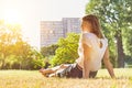 Rear view of young attractive businesswoman sitting on the grass while watching the sunset Royalty Free Stock Photo