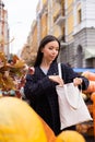 Portrait of young attractive casual woman looking for purse in bag at autumn farm shop