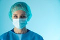 portrait of a young attractive Caucasian female doctor with a surgical mask and blue uniform closeup studio shot indoor Royalty Free Stock Photo