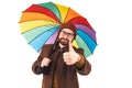 Portrait of young attractive Caucasian man holding a multicoloured umbrella and showing thumb up to the camera Royalty Free Stock Photo
