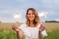 Portrait of young attractive celebrating woman holding sparkles.