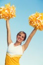 Portrait of young attractive cheerleader with pom poms