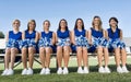 Portrait of young attractive Cheerleading Squad Sitting on Bench