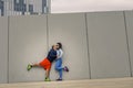 Portrait of young and attractive couple standing in front of the wall.