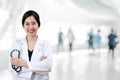 Portrait of young attractive female asian doctor or physician crossed arms holding stethoscope medical equipment