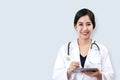 Portrait of young attractive female asian doctor or physician smiling and holding tablet and stethoscope medical equipment looking Royalty Free Stock Photo