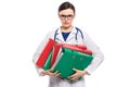 Angry young woman doctor with stethoscope holding binders in her hands in white uniform on white background Royalty Free Stock Photo