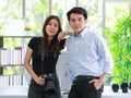 A portrait of young attractive female graphic designer holding a digital camera, standing next to a professional photographer Royalty Free Stock Photo