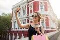 Portrait of young attractive feminine caucasian girl with dark hair in tan glasses and black dress smiling brightly Royalty Free Stock Photo