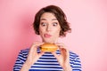 Portrait of young attractive funky hungry beautiful girl hold hamburger lick lips isolated on pink color background