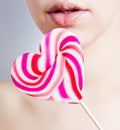 Portrait of a young attractive girl with a lollipop in the shape Royalty Free Stock Photo