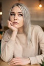 Portrait of young attractive thoughtful woman with long grey hair with cute professional make-up resting chin on hand. Royalty Free Stock Photo