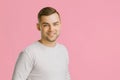 Portrait of a young attractive guy 20 years old on a pink isolated studio background. Royalty Free Stock Photo