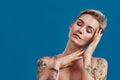 Portrait of a young attractive half naked tattooed woman with perfect skin closing eyes, gesturing sleeping isolated Royalty Free Stock Photo