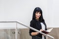 Portrait of Young Attractive happy brunette woman dressed in a black business suit working with a notebook, standing in office, Royalty Free Stock Photo