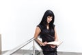 Portrait of Young Attractive happy brunette woman dressed in black business suit working with a notebook, standing in a office, Royalty Free Stock Photo