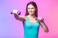 Portrait of young attractive happy woman in sport clothes with beautiful smile holding weight dumbbell doing fitness workout Royalty Free Stock Photo