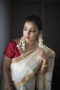 Portrait of an young and attractive Indian woman in white traditional wear for the celebration of Onam/Pongal Royalty Free Stock Photo