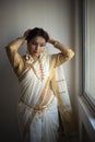 Portrait of an young and attractive Indian woman in white traditional wear  for the celebration of Onam/Pongal Royalty Free Stock Photo