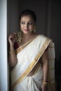 Portrait of an young and attractive Indian woman in white traditional wear for the celebration of Onam/Pongal Royalty Free Stock Photo