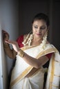 Portrait of an young and attractive Indian woman in white traditional wear for the celebration of Onam/Pongal Royalty Free Stock Photo