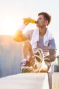 Portrait of young attractive man sitting while drinking energy drink