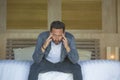 Portrait of young attractive overwhelmed and depressed man sitting on bed worried and frustrated suffering depression crisis fired Royalty Free Stock Photo