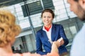 Portrait of young attractive passenger service agent giving boarding with passenger after check in at airport