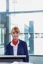 Portrait of young attractive passenger service agent standing in airport gate