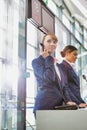 Portrait of young attractive passenger service agent talking on telephone while standing in airport gate