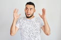 Portrait of excited Kazakh Asian man with a surprised open mouth throws up his hands on a white studio background
