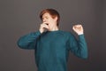 Portrait of young attractive red-haired male teenager with short hair in green sweatshort cothing mouth with hand Royalty Free Stock Photo