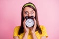 Portrait of young attractive shocked amazed surprised girl staring camera cover face hold clock isolated on pink color Royalty Free Stock Photo