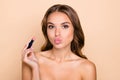 Portrait of young attractive stunning woman pout lips kiss showing nude lipstick tone isolated on beige color background