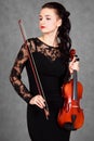 Portrait of a young attractive violinist woman in a black evening dress Royalty Free Stock Photo