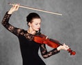 Portrait of a young attractive violinist woman in a black evening dress