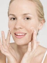 Portrait of young attractive woman applying facial cream Royalty Free Stock Photo