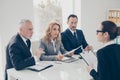 Portrait of young attractive woman in glasses having job interview with three stylish business persons in financial Royalty Free Stock Photo