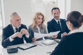 Portrait of young attractive woman in glasses having job interview with three stylish business persons in financial Royalty Free Stock Photo