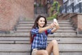 Portrait of a young attractive woman holding a smartphone digital camera with her hands and taking a selfie self portrait of hers Royalty Free Stock Photo