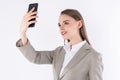 Portrait of a young attractive woman making selfie photo on smartphone isolated on a white background Royalty Free Stock Photo