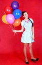 Portrait of a young attractive woman with many bright balloons